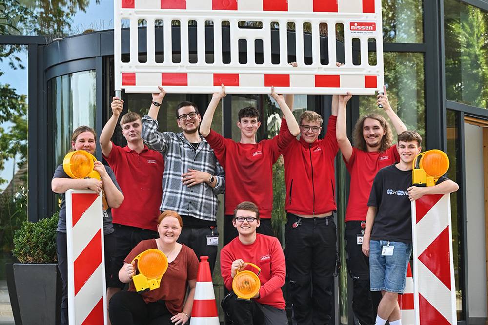 Gruppe von Azubis der Firma Nissen mit Schild